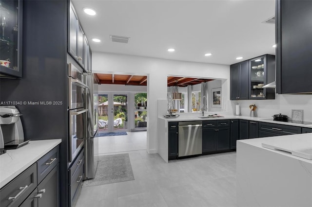 kitchen featuring french doors, sink, stainless steel dishwasher, light stone countertops, and stovetop