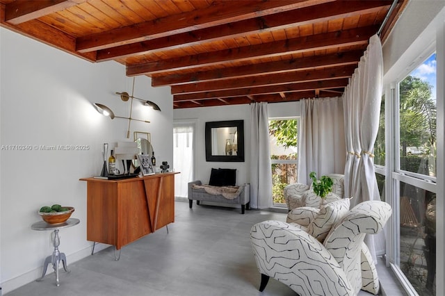 sitting room with beam ceiling, a healthy amount of sunlight, concrete floors, and wooden ceiling