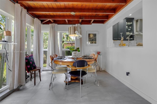 dining room with beam ceiling, wood ceiling, and concrete floors