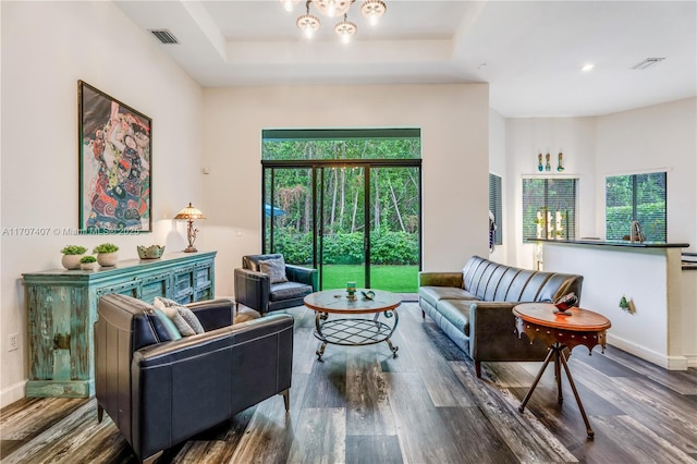 living room with wood finished floors, visible vents, and a healthy amount of sunlight