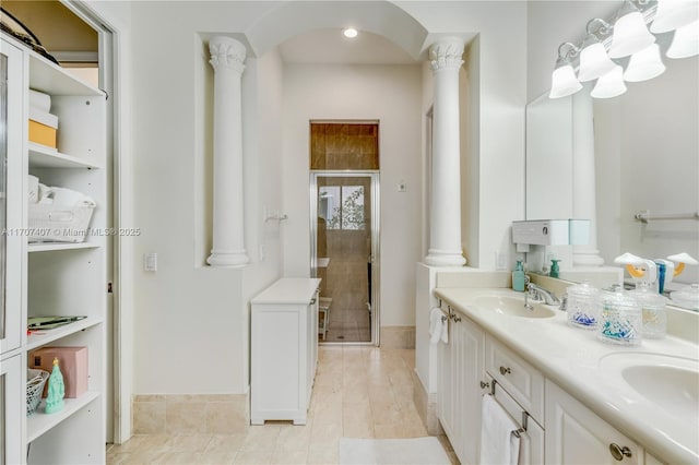 bathroom with tile patterned flooring, vanity, decorative columns, and a shower with door