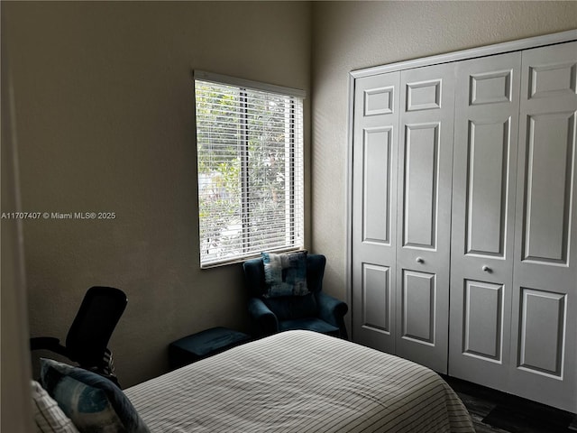 bedroom featuring a textured wall and a closet