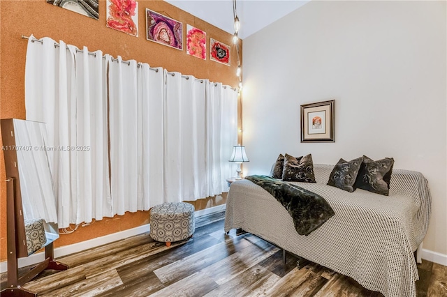 bedroom with baseboards and wood finished floors