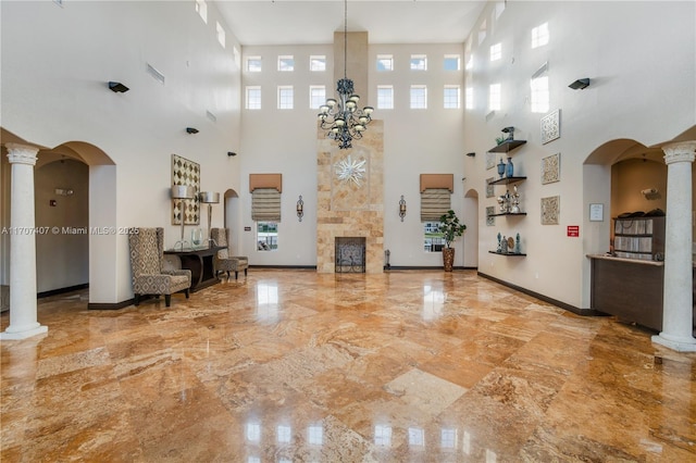 unfurnished living room featuring marble finish floor and decorative columns