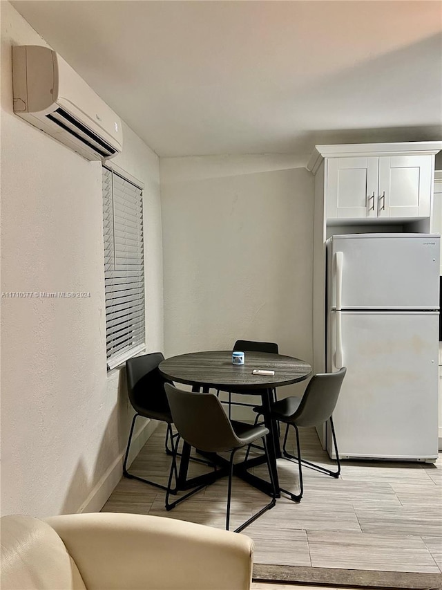 dining area with light wood-type flooring and a wall mounted AC