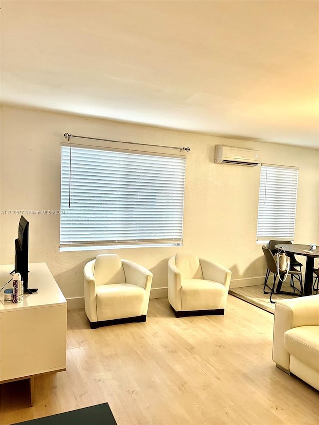 living room with light hardwood / wood-style floors and a wall mounted AC