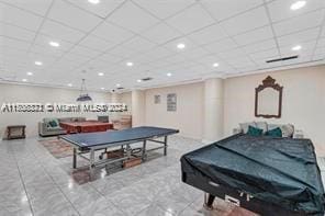 recreation room with tile patterned flooring and a drop ceiling