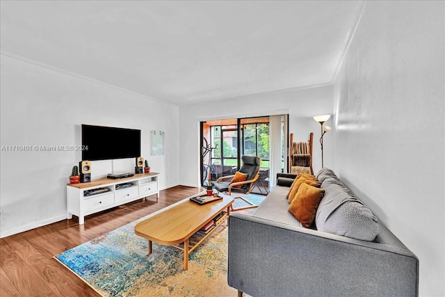 living room with hardwood / wood-style flooring and crown molding