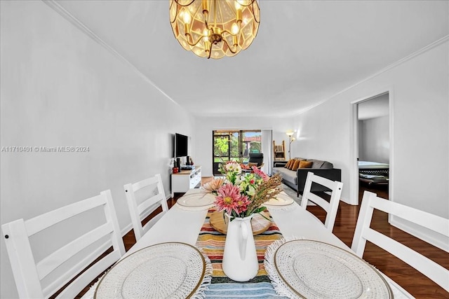 dining space featuring hardwood / wood-style floors, ornamental molding, and an inviting chandelier