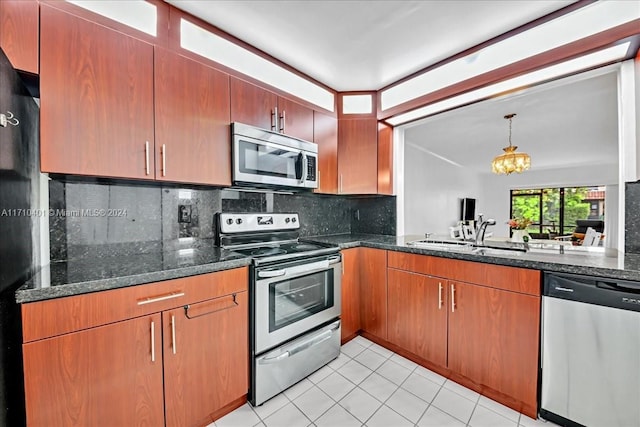 kitchen featuring appliances with stainless steel finishes, backsplash, sink, light tile patterned floors, and a chandelier