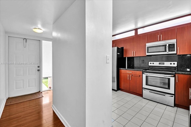 kitchen with decorative backsplash, light tile patterned flooring, and appliances with stainless steel finishes