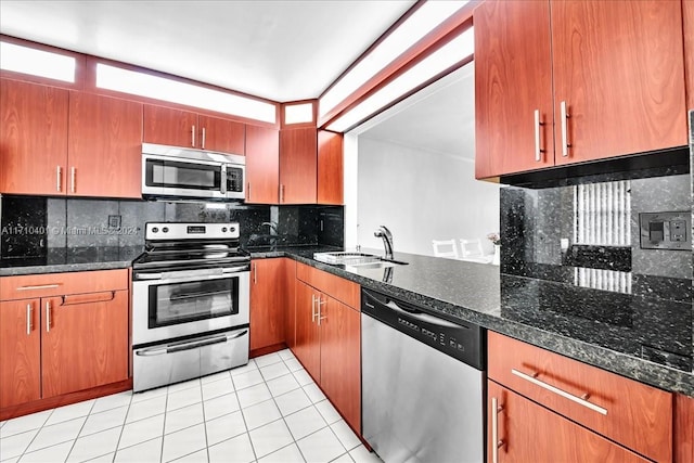 kitchen with backsplash, dark stone counters, sink, light tile patterned flooring, and stainless steel appliances