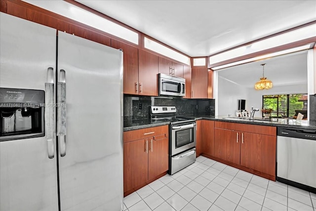 kitchen with pendant lighting, backsplash, sink, stainless steel appliances, and a chandelier