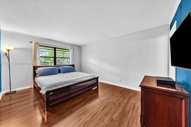 bedroom featuring wood-type flooring and ornamental molding