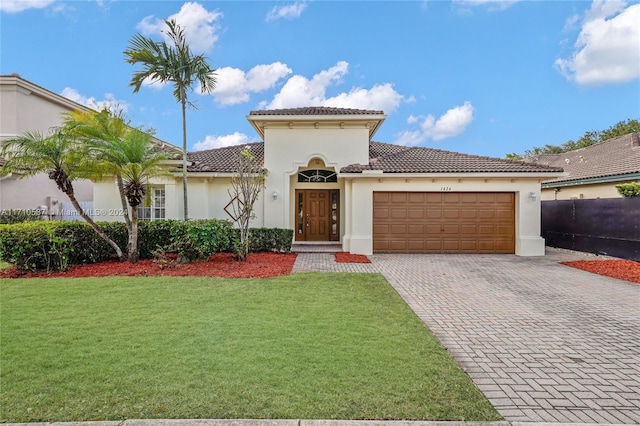 mediterranean / spanish house with a garage and a front lawn