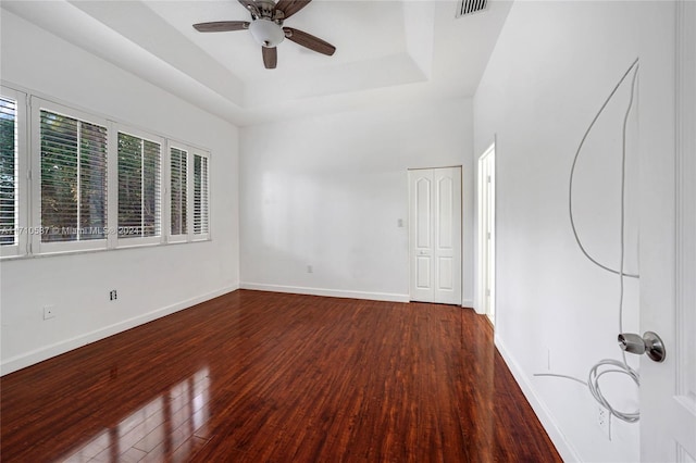 unfurnished room featuring wood-type flooring, a raised ceiling, and ceiling fan