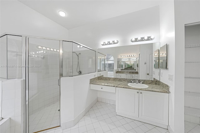 bathroom featuring tile patterned floors, vanity, a shower with door, and vaulted ceiling