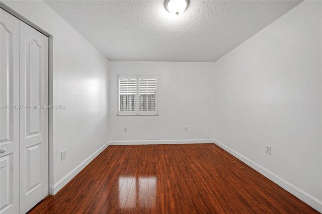 interior space with a closet, dark wood-type flooring, and a textured ceiling