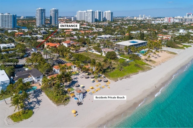 birds eye view of property with a water view and a beach view