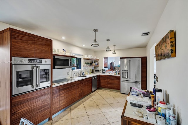 kitchen featuring decorative light fixtures, sink, light tile patterned floors, and stainless steel appliances