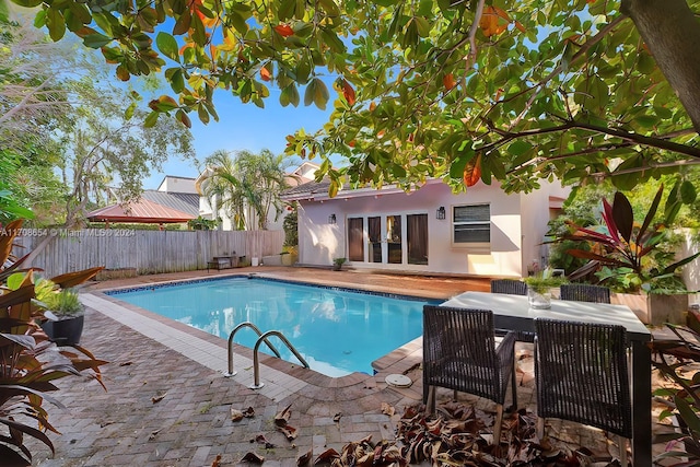 view of swimming pool featuring a patio area and french doors