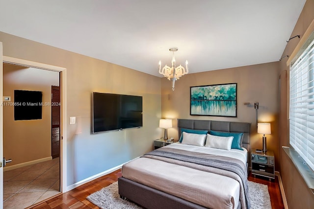 bedroom featuring dark wood-type flooring and a notable chandelier