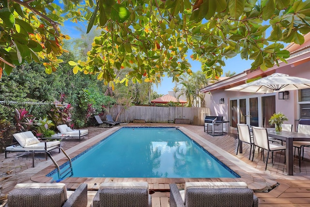 view of swimming pool with area for grilling, a patio, and french doors