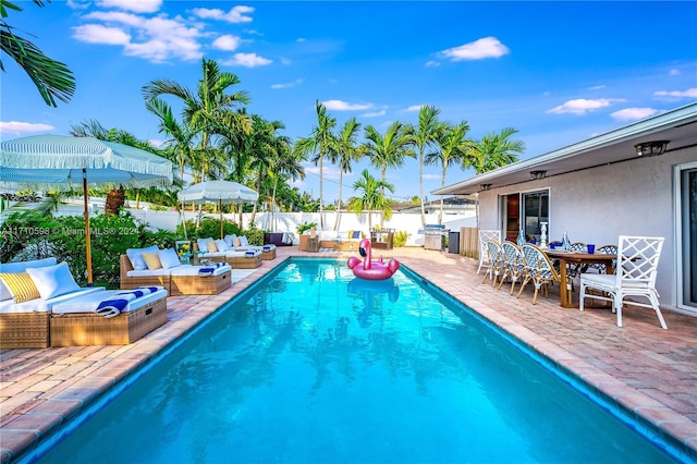 view of swimming pool with outdoor lounge area, area for grilling, and a patio