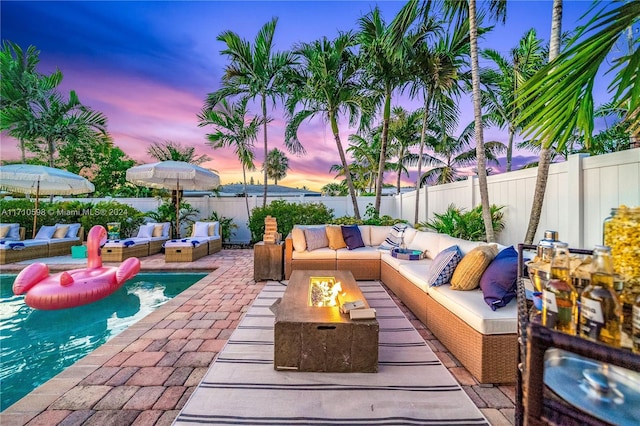 patio terrace at dusk with an outdoor living space with a fire pit