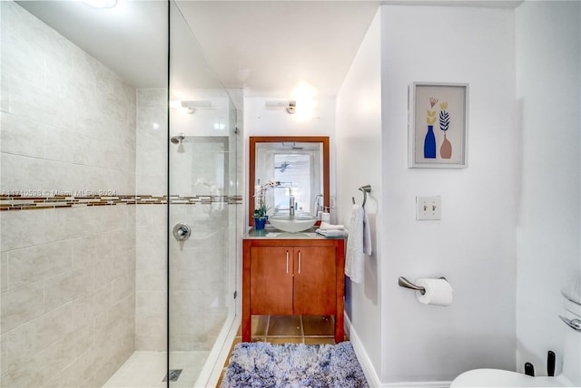 bathroom with tiled shower and vanity