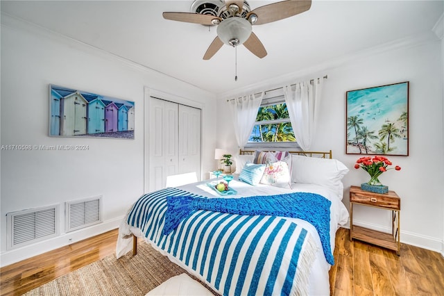 bedroom featuring crown molding, ceiling fan, a closet, and wood-type flooring