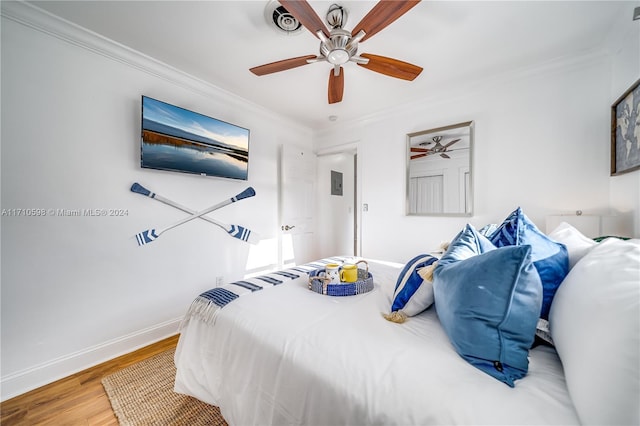 bedroom with hardwood / wood-style floors, ceiling fan, and crown molding