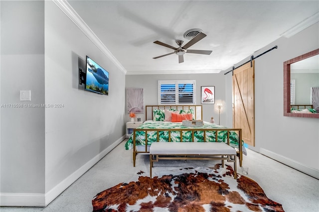 bedroom featuring ceiling fan, a barn door, and ornamental molding