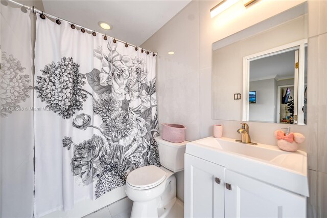 bathroom with tile patterned floors, walk in shower, vanity, crown molding, and toilet