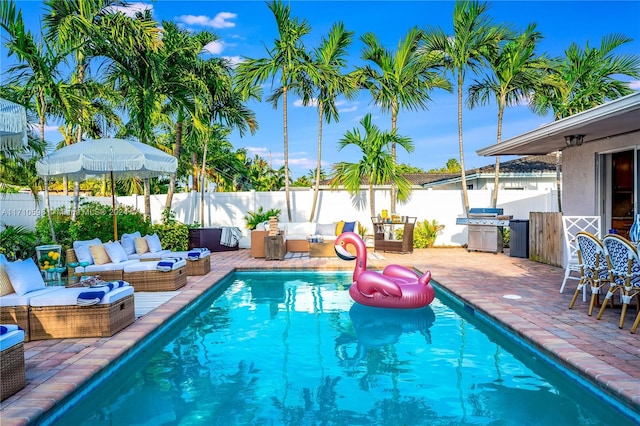 view of pool featuring a grill, a patio area, and an outdoor hangout area