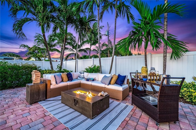 patio terrace at dusk featuring an outdoor living space with a fire pit