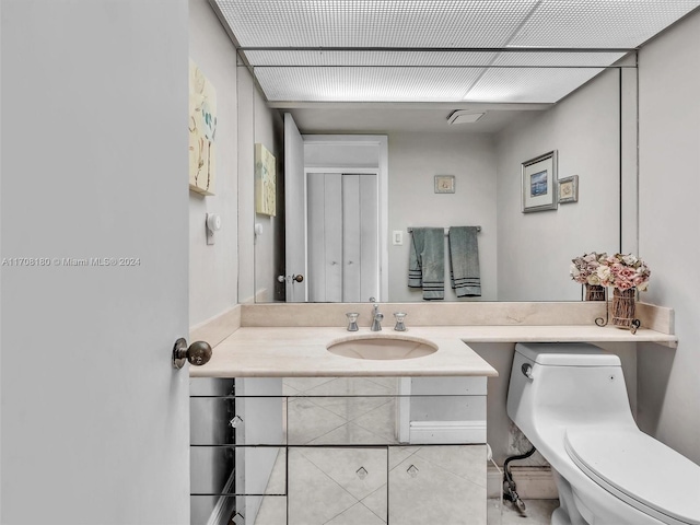 bathroom with tile patterned flooring, vanity, and toilet