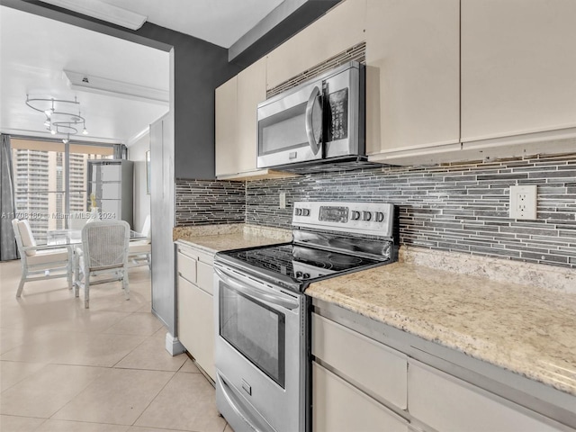 kitchen featuring a chandelier, light tile patterned floors, stainless steel appliances, and tasteful backsplash