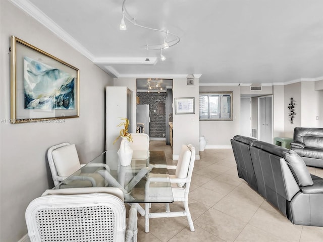 tiled dining area featuring rail lighting and crown molding