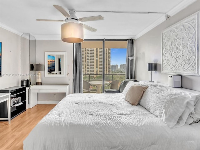 bedroom with hardwood / wood-style flooring, ceiling fan, and ornamental molding