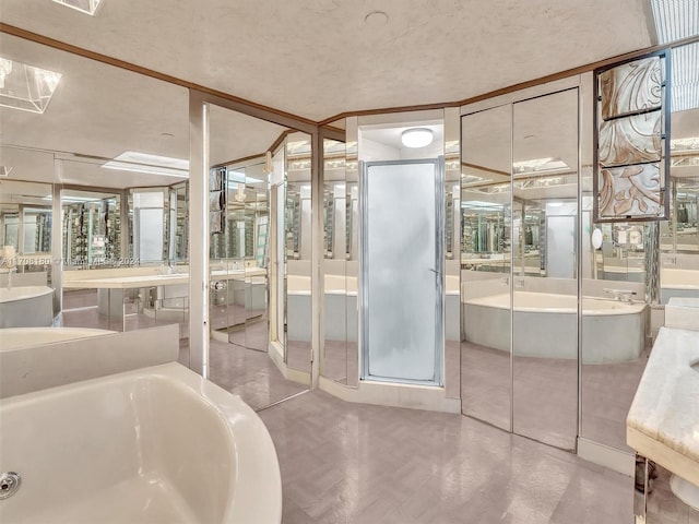 bathroom featuring vanity, a bath, and a textured ceiling