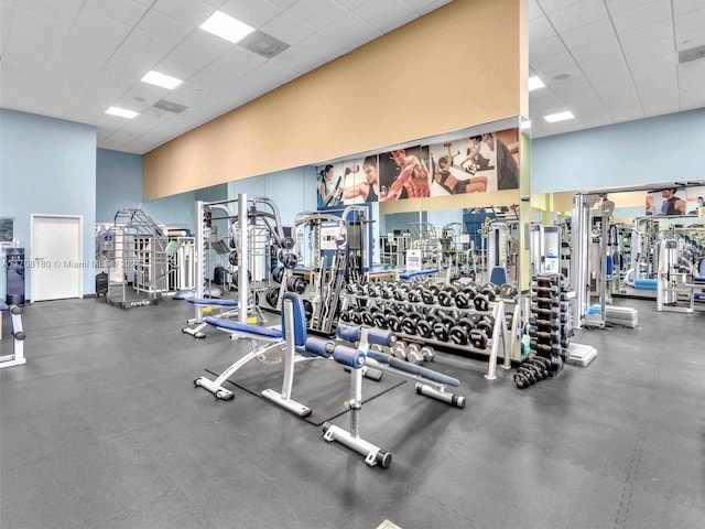 gym featuring a drop ceiling and a towering ceiling