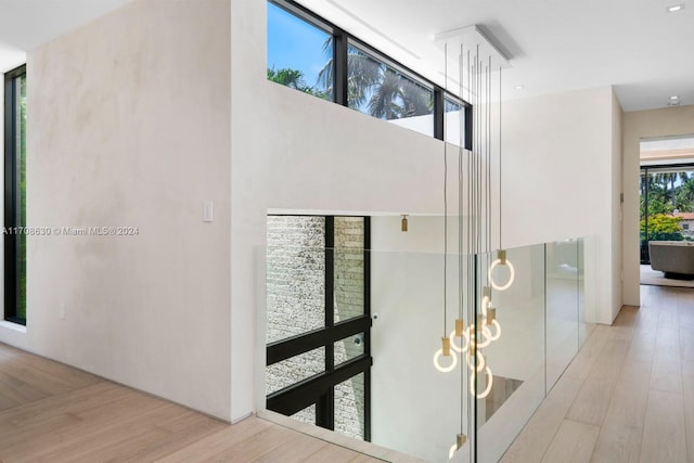 hallway featuring light hardwood / wood-style flooring and a towering ceiling