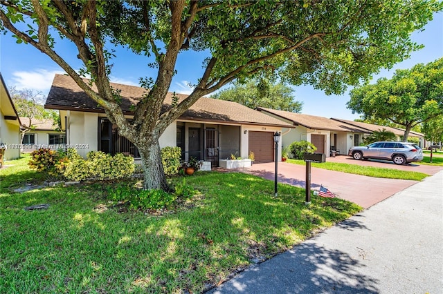 ranch-style home featuring a front lawn and a garage