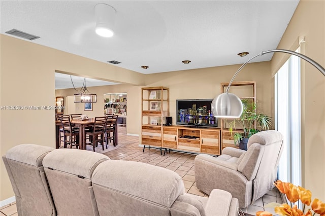 living room with light tile patterned floors and a notable chandelier