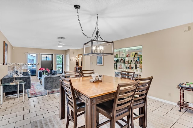 dining space with a notable chandelier and light tile patterned flooring