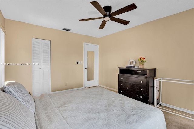 bedroom with ceiling fan, light colored carpet, and a closet