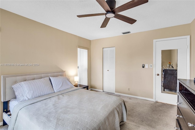 bedroom featuring a textured ceiling, carpet floors, a closet, and ceiling fan