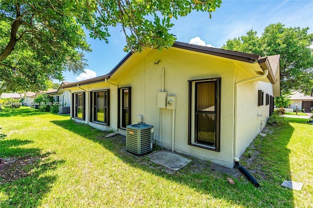 back of property featuring a yard and cooling unit