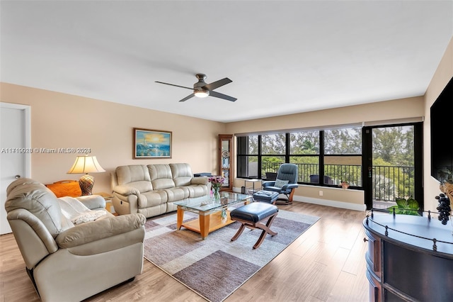 living room featuring ceiling fan and light hardwood / wood-style flooring